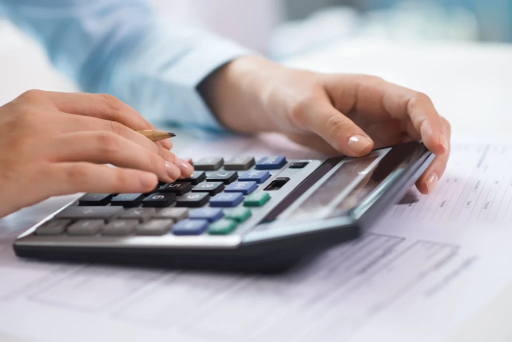 Business professional using calculator for UAE VAT calculation, tax filing, financial reporting, accounting, and corporate tax compliance services.